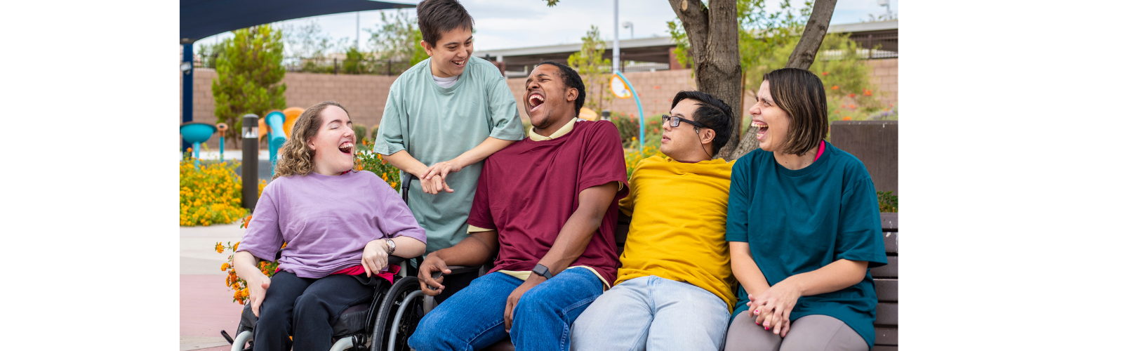 Students are outside of a school. They are looking at each other and smiling.
